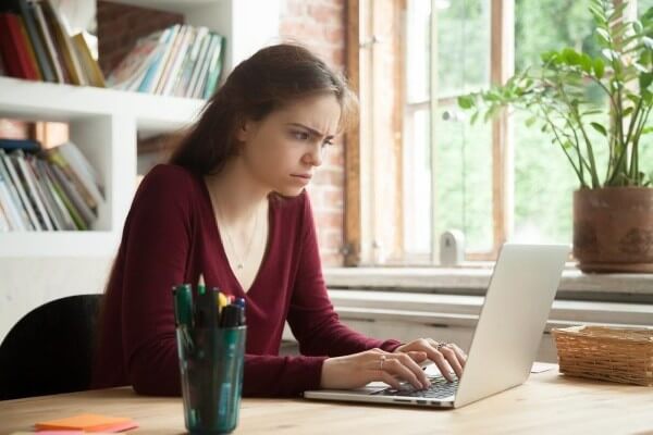 Puzzled woman looking at a suspicion information on her laptop Email terminology